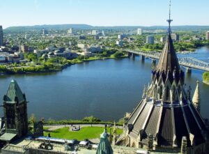 A view of Ottawa, featuring the Ottawa River, Parliament Hill buildings, and the Alexandra Bridge with the city and distant hills in the background, showcases an ideal setting for MCW Group's upcoming expansion.