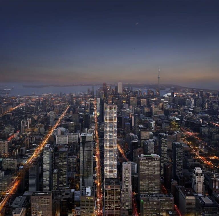 Aerial view of a city skyline at dusk with Mizrahi Developments' illuminated streets and buildings, under a dimly lit sky.