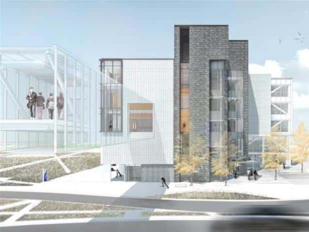 Modern multi-story building with glass and brick facade, connected by a skybridge; people visible inside the structure. Trees and a road in the foreground, with a blurred vehicle passing by. This impressive construction is part of Sheridan College, renowned for its advanced learning facilities.